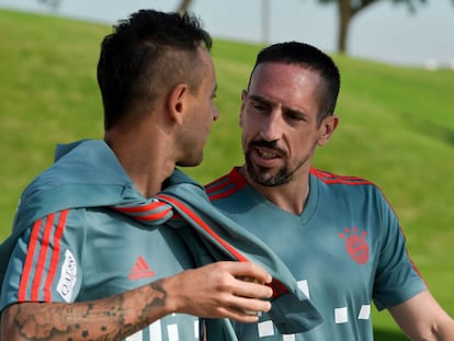 Ribery (D) habla con Rafinha en el entrenamiento de este domingo.  