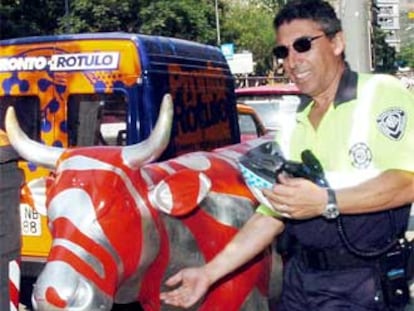 Un guardia urbano de Barcelona muestra la vaca que desapareció el pasado lunes.