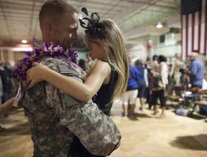 Un soldado sostiene a una niña durante una ceremonia de bienvenida en la base de Wheeler, en Wahiawa, Hawai, el 6 de diciembre de 2011.