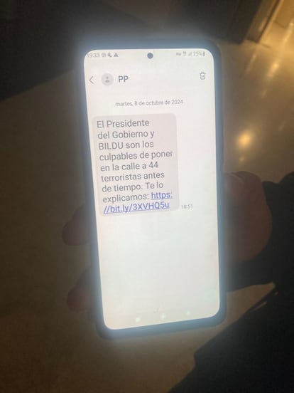 Un afiliado del PP muestra el mensaje de SMS recibido en su móvil este martes.