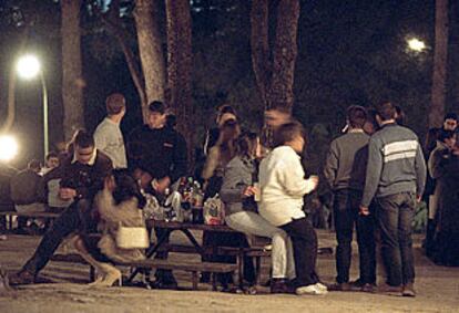 Jóvenes consumiendo alcohol durante un <b></b><i>botellón</i> en un parque de Madrid.