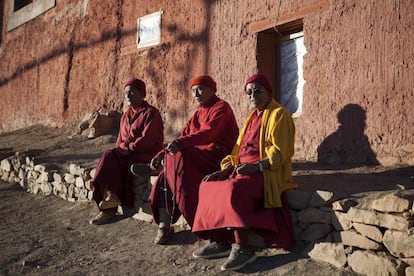 Nawang Tsultrim, 54, Lobzan Nyenda, 68, y Tashi Jamphel, 71, se sientan bajo el sol de la tarde mientras rezan en el monasterio Tnagyud Gompa.