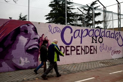 Dos personas pasan por el mural feminista en el polideportivo municipal de la Concepción en el distrito de Ciudad Lineal.