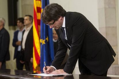 El presidente de la Generalitat, Carles Puigdemont, firma el documento sobre la Independencia en el Parlament. EFE/Quique García