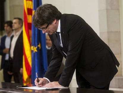 El presidente de la Generalitat, Carles Puigdemont, firma el documento sobre la Independencia en el Parlament. EFE/Quique García