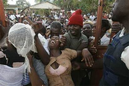 Una mujer intenta entrar a la fuerza a un colegio electoral haitiano, en el pueblo de Marmelde.