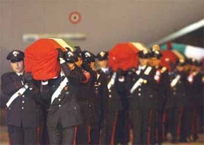 Los compañeros de los policías italianos muertos portan sus féretros en el aeropuerto de Ciampino.