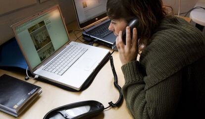 Una mujera habla por teléfono mientras consulta Internet
