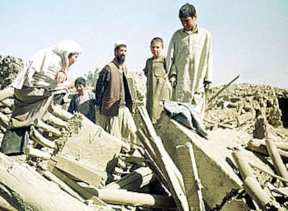 Un grupo de afganos mira los escombros de lo que fue su barrio, destruido por una bomba de EE UU.