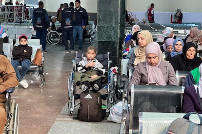 Un niño palestino enfermo de cáncer (en el centro) espera en la sala de llegadas egipcia de la frontera de Rafah, antes de ser trasladado a Emiratos Árabes para recibir tratamiento, este domingo.