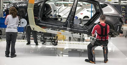 Una mujer y un hombre trabajando en la cadena de montaje del Seat Le&oacute;n en la planta de Martorell, Barcelona.