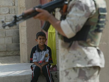 Dos niños miran a un soldado iraquí en Yusufiya (sur de Bagdad).