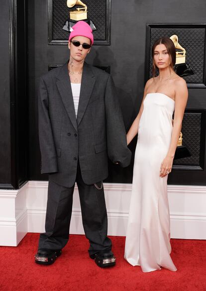 Justin Bieber, nominado en ocho categorías, posa con un traje oversize de Balenciaga junto a Hailey Bieber, que lleva un sencillo vestido de Saint Laurent.