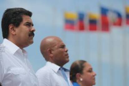 Fotografía cedida por la prensa de Miraflores que muestra al presidente de Venezuela, Nicolás Maduro (i), acompañado de su homólogo haitiano, Michel Martelly (c), y su esposa Sophia (d), a su llegada a Puerto Príncipe (Haití).