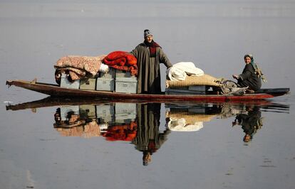 Una pareja transporta sus pertenencias a un lugar más seguro tras quedar sus casas destruidas por un incendio en Dhobi Ghat, en las afueras de Srinagar. Al menos 14 casas residenciales fueron destrozadas por el fuego en la noche del domingo.