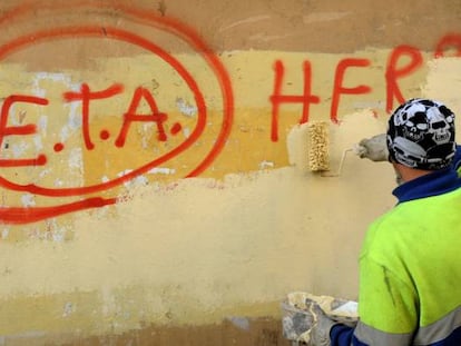 A municipal worker cleaning up graffiti in Guernica.