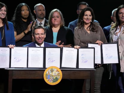 Florida Gov. Ron DeSantis holds up bills he signed during a bill signing ceremony at the Coastal Community Church at Lighthouse Point, Tuesday, May 16, 2023, in Lighthouse Point, Fla.