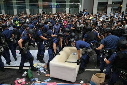 Más de 80 personas han sido detenidas en las últimas horas durante el desalojo de la acampada en el área de Mong Kok, según la policía. En total, los detenidos desde el inicio de las operaciones, a primera hora del martes, suman 116. En la imagen, agentes de policía retiran un sillón de la zona de acampada.
