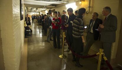 Una fila de periodistas esperan en un vestíbulo del sótano el resultado de la votación de la Cámara de Representantes.