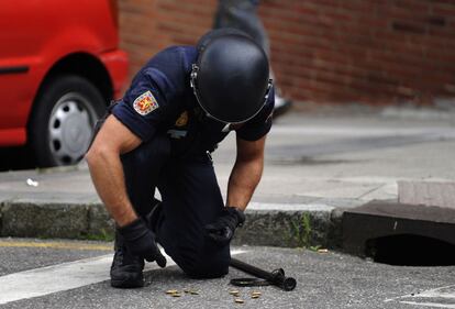 Un policía recoge las balas que se le han caído durante las protestas contra el desahucio.