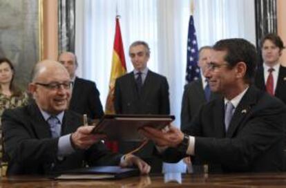 El ministro de Hacienda, Cristóbal Montoro, y el embajador de EEUU en España, Alan D. Solomont (d), durante la firma hoy de un nuevo convenio entre ambos países para evitar la doble imposición y prevenir la evasión fiscal respecto a los impuestos sobre la renta.