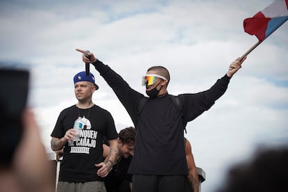 Residente y Bad Bunny, con un micrófono y una bandera puertorriqueña, en las manifestaciones para pedir la dimisión del gobernador de Puerto Rico Ricardo Rosselló, en San Juan, en julio de 2019.