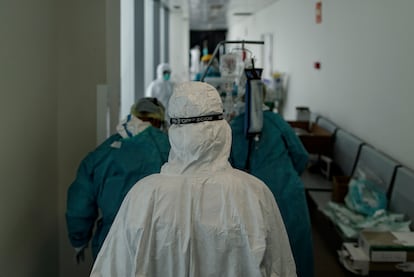 Personal sanitario totalmente protegido traslada a un paciente ingresado en la Unidad de Cuidados Intensivos del Hospital Infanta Sofía en San Sebastián de los Reyes.