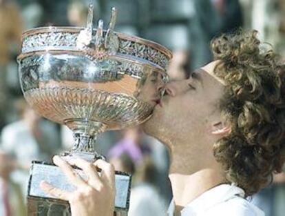 Kuerten besa el trofeo que le acredita como campeón de Roland Garros.