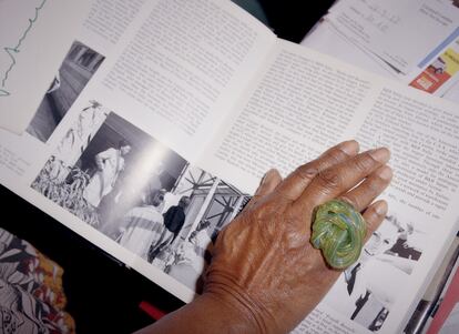 La mano de Garva Griffin acaricia uno de los miles de libros de decoración que ocupan toda su casa. 