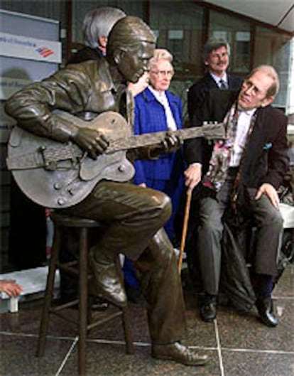 Chet Atkins contempla una estatua de bronce erigida en su honor en Nashville en enero del año pasado.