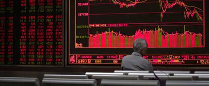 Un hombre contempla un monitor con cotizaciones bursátiles en una casa de corretaje de acciones de Pekín.