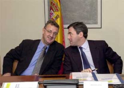 El ministro de Justicia, Angel Acebes (d), conversa con el portavoz del Grupo Socialista, Jesús Caldera (i).