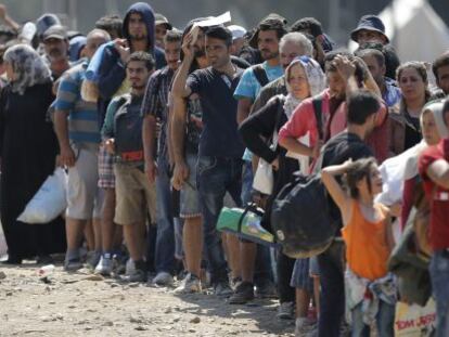 Refugiados esperan para poder cruzar la frontera entre Macedonia y Grecia