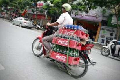 Un hombre transporta en su motocicleta cajas con botellas de Coca-Cola en una calle de Hanoi, Vietnam.