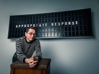 El artista alemán Mario Klingemann posa frente a su pieza 'Appropriate Response', en la que el visitante se reclina frente a un panel negro en el que una inteligencia artificial crea frases. "No quiero decir que la tecnología sea un dios, pero como un dios no sabemos qué quiere, y buscamos una respuesta de ella", dice. |