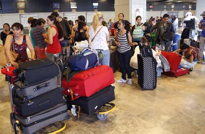 Un grupo de viajeros espera en el aeropuerto madrile&ntilde;o de Barajas.