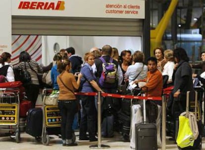 Pasajeros damnificados por los retrasos en Barajas, ayer en la cola del mostrador de atención al cliente de Iberia.