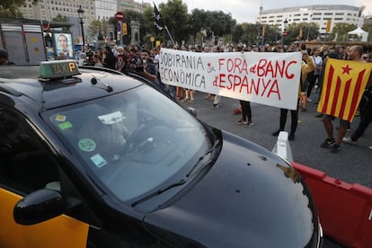 Otra imagen de los cortes de trafico en Plaza de Cataluña provocados por los miembros de los CDR para conmemorar el aniversario del referéndum del 1-O. En la pancarta se puede leer: 'Soberanía económica. Fuera el Banco de España'.