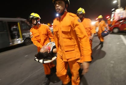 Manifestante contrária ao impeachment desmaia e é resgatada pelos bombeiros durante um protesto diante do Senado, em Brasília. O desmaio ocorreu após ela ser atingida por jatos de spray de pimenta da Polícia Militar.