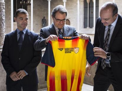 Artur Mas (dentro) recibe una camiseta de la seleccion catalana de futbol.