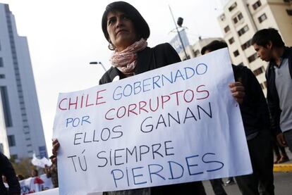 Una manifestante sostiene una pancarta durante una protesta donde exigen educación gratuita, de calidad y manifiestan su descontento por la corrupción de la clase política en Santiago de Chile.
