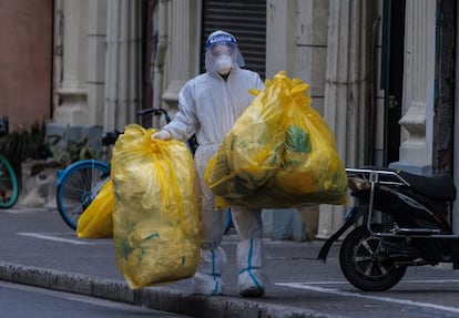 Un trabajador con residuos sanitarios de una de las zonas confinadas en Shanghái, el martes.