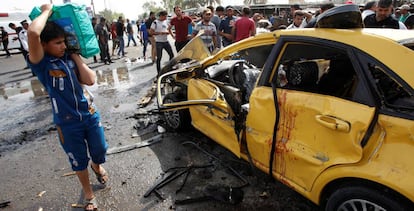 Un joven pasa junto a los destrozos dejados por un coche bomba en el barrio chi&iacute; de Ciudad Sader, en Bagdad.