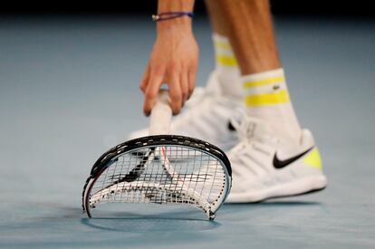 Medvedev recoge su raqueta tras estrellarla contra la pista de la Rod Laver Arena de Melbourne.