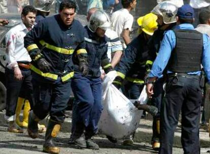 Varios bomberos evacuan el cuerpo de la víctima de la explosión de un coche bomba ayer en Bagdad.