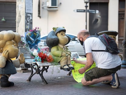 Un hombre deja un tributo en las esculturas que representan a Mafalda y sus amigos en el barrio de San Telmo, en Buenos Aires, el 30 de septiembre de 2020.