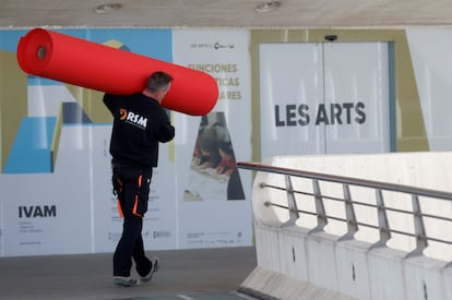 Un operario traslada la alfombra roja al interior del Palau de Les Arts, en Valencia.
