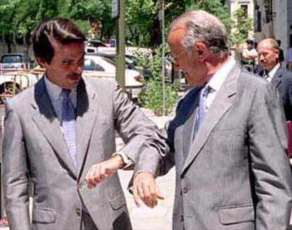 Aznar y el presidente del Poder Judicial, Javier Delgado, bromean sobre el parecido de sus trajes.