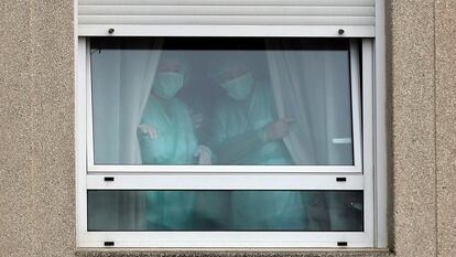 Dos trabajadoras, en una ventana de DomusVi San Lázaro, en Santiago de Compostela.