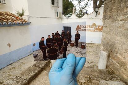 Miembros de una banda de música momentos antes de participar en una procesión de Semana Santa, en abril de 2019. Al fondo, el mismo lugar el 5 de abril.